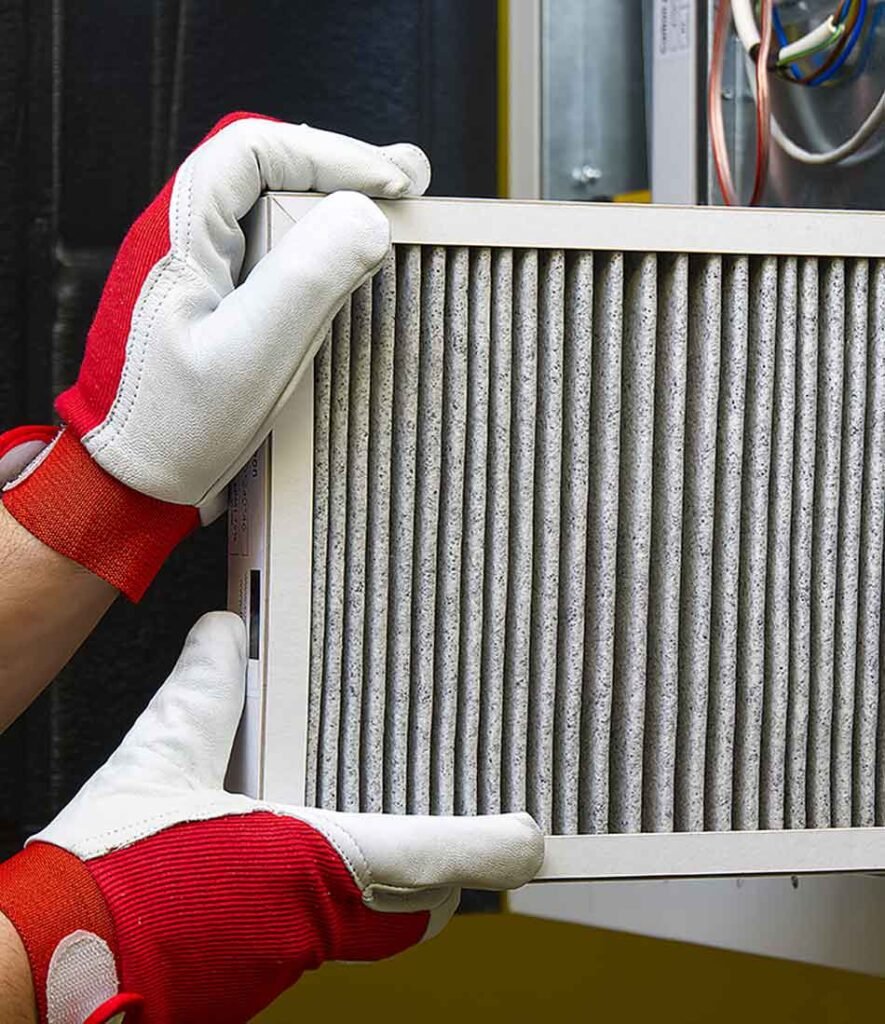 Technician replacing a dirty air filter during an air duct cleaning service.