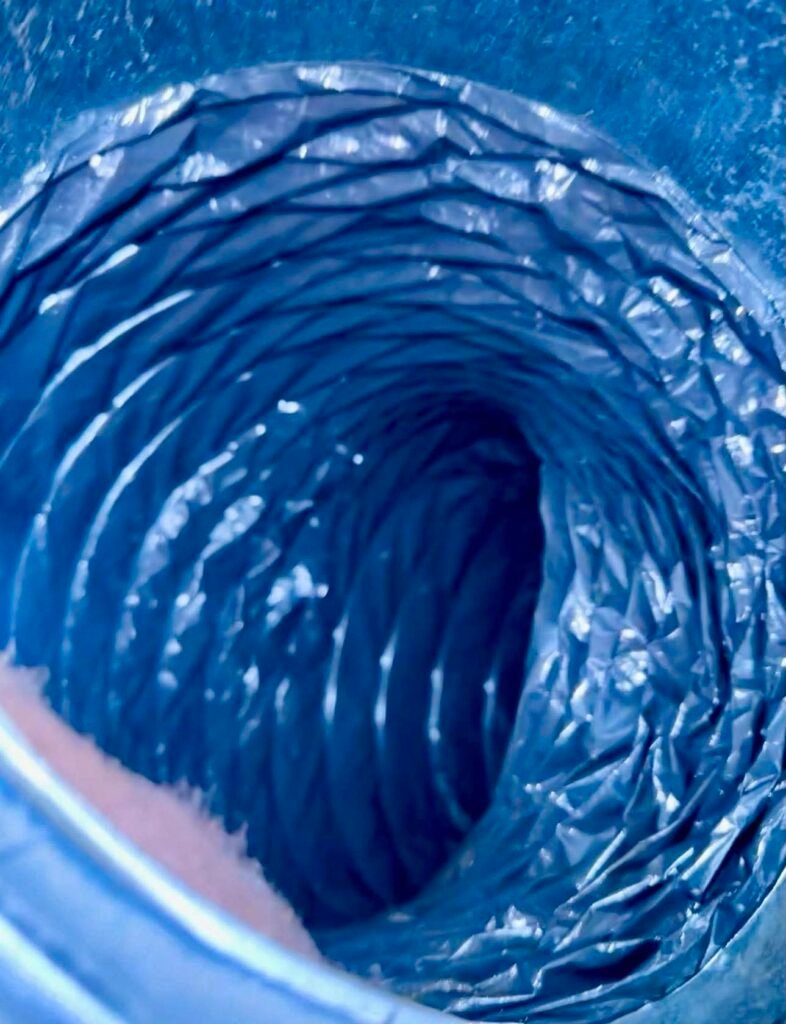 Curved flexible residential air duct after professional cleaning cleared the interior buildup