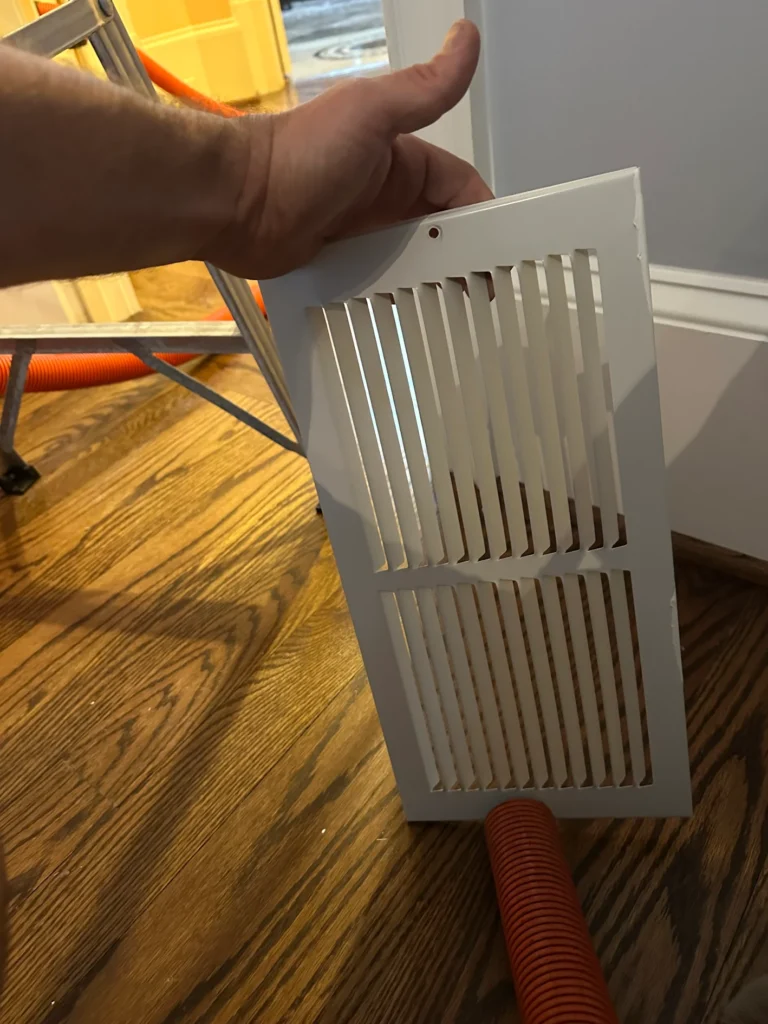 Residential air register after cleaning removed dust from the grille and louvers