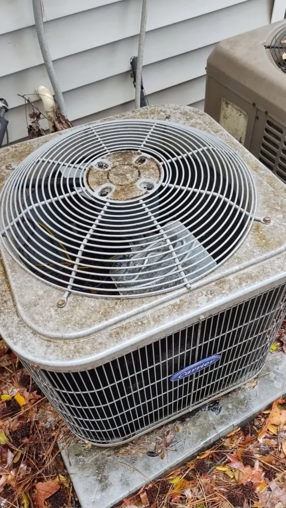 Outdoor Carrier AC condenser covered with dirt and debris before professional cleaning