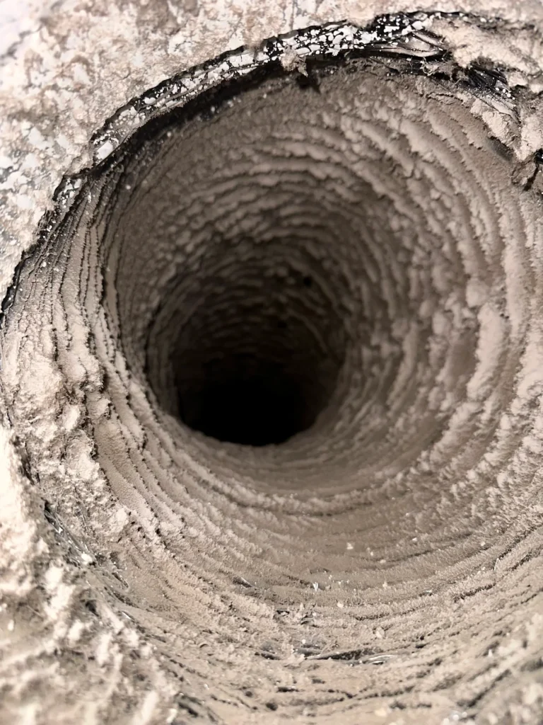 Heavy dust and debris buildup inside a flexible residential air duct before cleaning